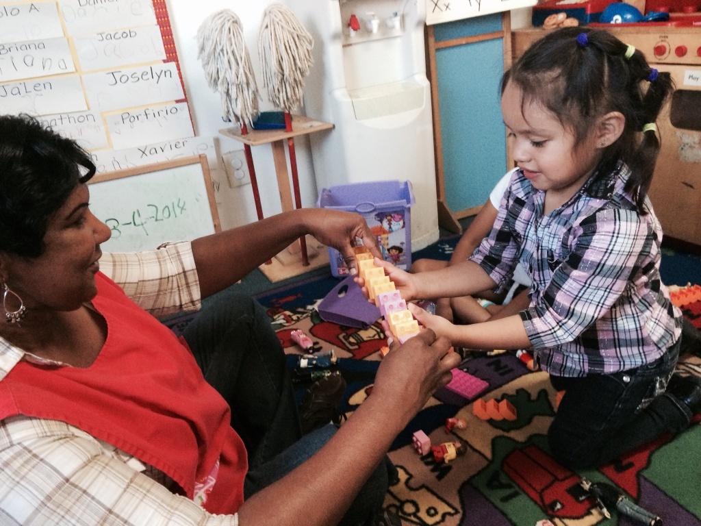 Compton Preschool At Heavenly Vision Educational Center in Compton, 4 year-old Charlenne De Leon instructs the teacher Merleen Wade how to build a water slide out of lego blocks during free play.