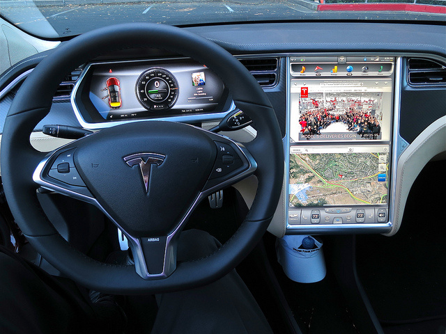 The interior of a Tesla car with displays for a web browser, Google Map view and a dashboard view that includes the odometer and a picture of the album that's being streamed from a cloud service. The interior of a Tesla car with displays for a web browser, Google Map view and a dashboard view that includes the odometer and a picture of the album that's being streamed from a cloud service.