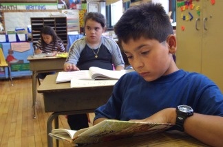 A student in Ms. Newman''s third grade class reads a book during summer school July 3, 2001 at Brentano Academy in Chicago.