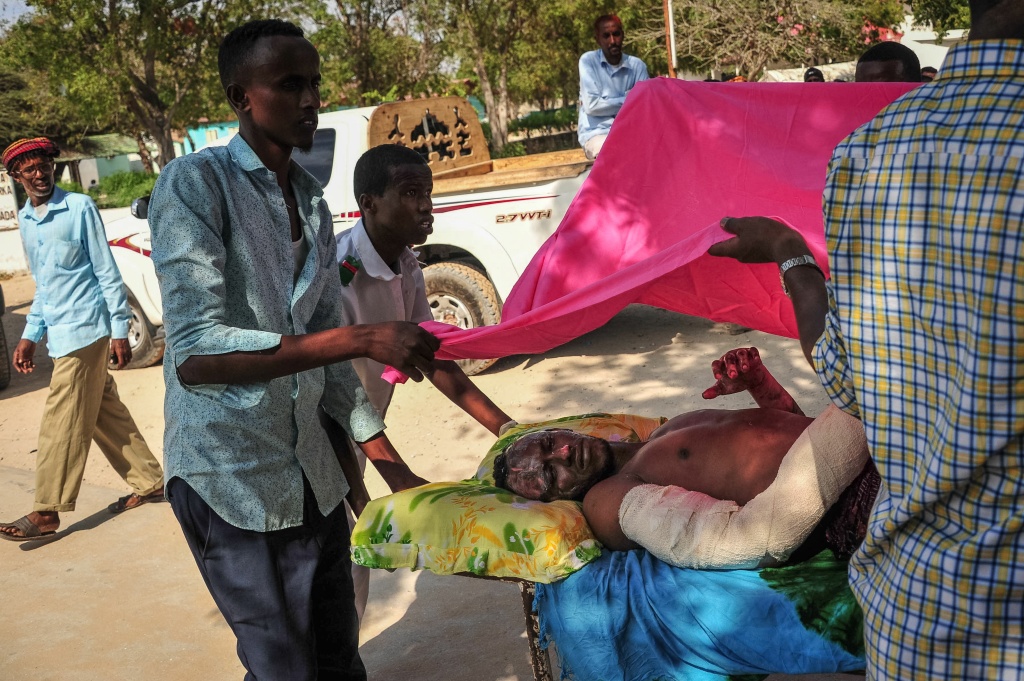 SOMALIA-BOMBING-CONFLICT Two men carry a man who was injured when a truck bomb exploded in the center of Mogadishu on October 15, 2017.