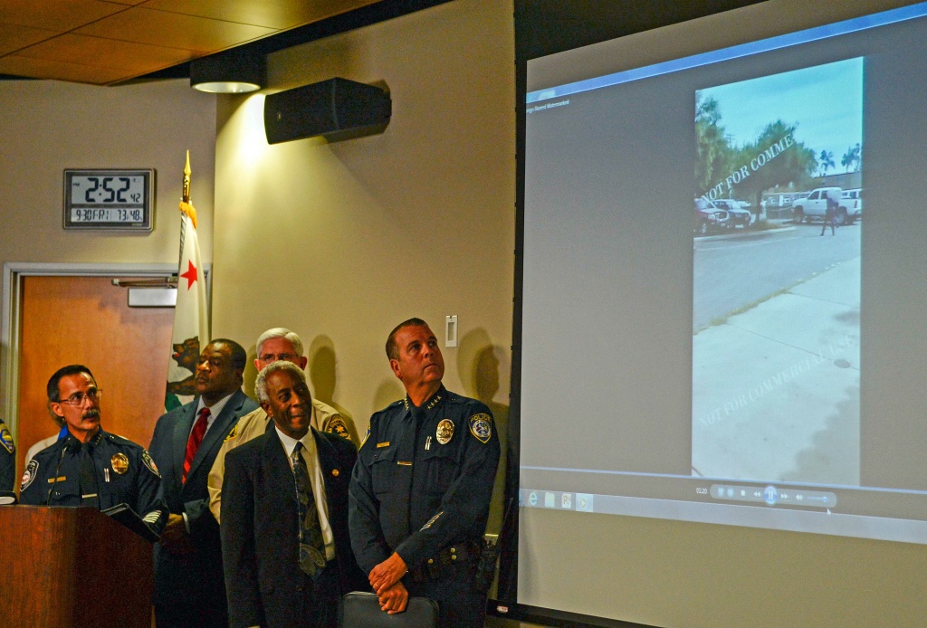 Authorities watch a video of the shooting scene at a news conference on Sept. 30, 2016, in El Cajon, Calif, that was held to address the killing of Alfred Olango, a Ugandan refugee shot by an El Cajon police officer. The El Cajon police department released video footage of the shooting at the news conference.