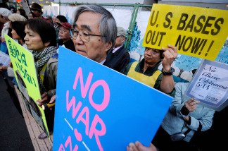 People hold banners in front of the Diet building in Tokyo on May 14, 2010 during a rally denouncing US bases in Okinawa, Japan's southernmost prefecture. Hundreds of people took part in the rally demanding withdrawal of US bases from Okinawa
