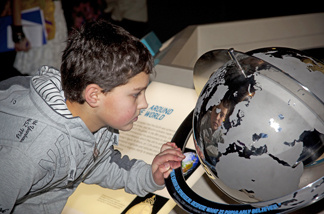 "A child studies a globe at the "1001 Inventions" exhibit on Muslim scientific contributions throughout history. The traveling exhibit runs at the California Science Center through December.