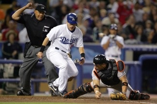 Paul Lo Duca, No. 16 of the Los Angeles Dodgers, is out at home plate as Javy Lopez, No. 18 of the Baltimore Orioles, keeps his foot on home plate in the fourth inning as home plate umpire Kerwin Danley makes the call on June 17, 2004 at Dodger Stadium.