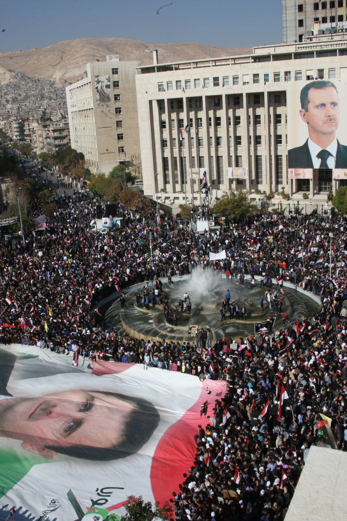 A giant portrait of embattled Syrian Pre A giant portrait of embattled Syrian President Bashar al-Assad is carried in a sea of thousands of Syrian demonstrators in the capital Damascus on November 28, 2011. Protesters waved Syrian flags and chanted nationalist songs in a demonstration against the Arab League decision to impose crippling sanctions on President Bashar al-Assad's regime. Syria has also come under sharp criticism from an independent commission that accused the security forces of systematically carrying out abuses against anti-government demonstrators.