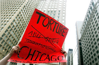 Adam Turl displays his sign regarding police torture during a demonstration July 21, 2006 in downtown Chicago, Illinois.
