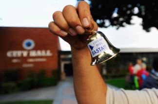 A resident celebrates the arrest of eight former and current Bell city officials by shaking little bells in front of City Hall on Sept. 21, 2010. The city officials were charged with misappropriation of more than $5.5 million in public funds for excessive salaries and illegal personal loans.