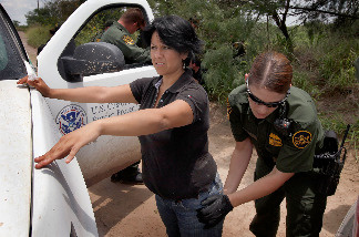 A Border Patrol agent searches an undocumented immigrant apprehended near the Mexican border on May 27, 2010 near McAllen, Texas.